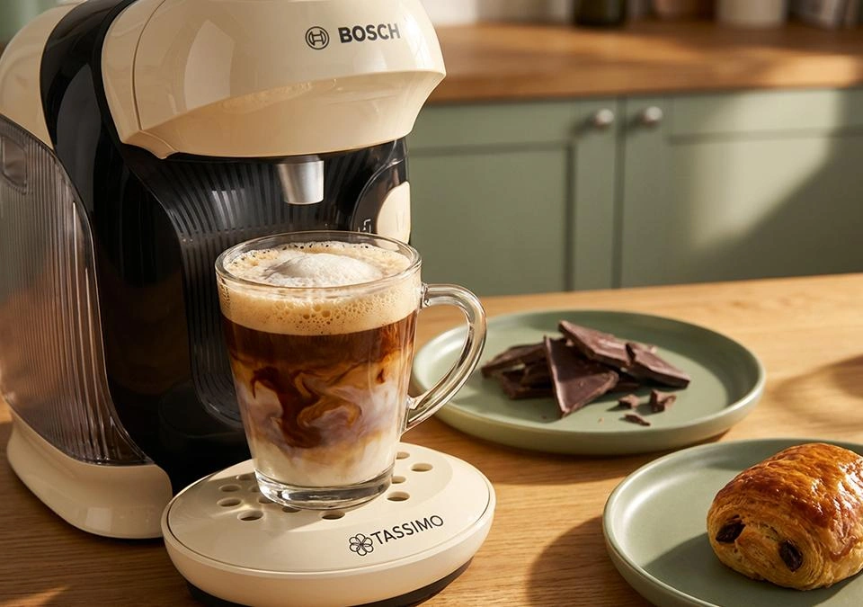 Cremiger Mocha Kaffee in einer Tasse mit Schokoladentopping und Milchschaum auf einem hellen Tisch.