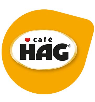 Café HAG logo on a yellow background with TASSIMO branding and a red heart.
