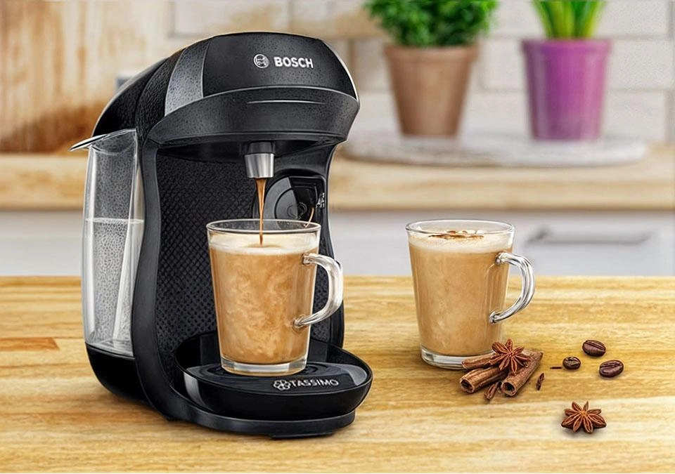 A TASSIMO coffee machine brews a spiced latte, surrounded by aromatic coffee beans and fragrant spices.