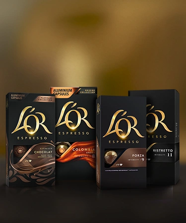 L'OR coffee capsules arranged on a dark table with various variants.