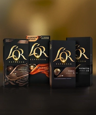L'OR coffee capsules arranged on a dark table with various variants.