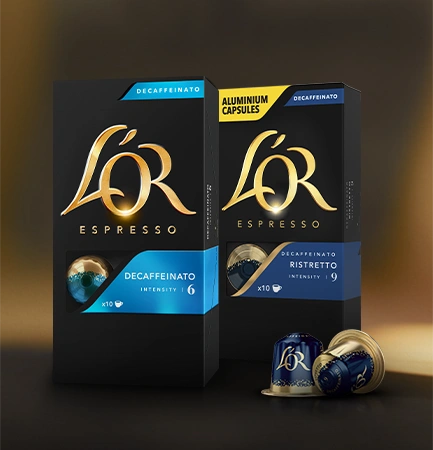 Enhance your coffee experience with L'OR Espresso coffee pods, elegantly presented in a glass cup on a wooden tray.