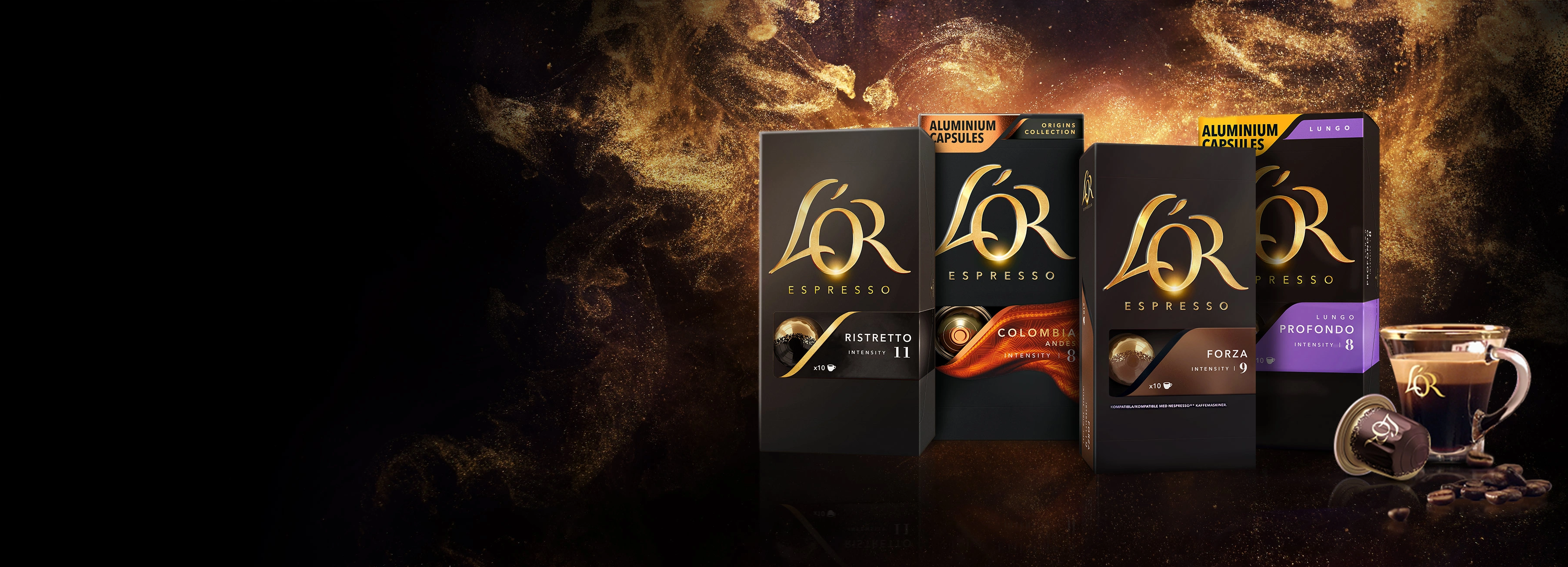 Variety of L'OR Ristretto, Colombia, Forza and Profondo packs. L'OR capsule and and espresso cup. Golden glitter background.