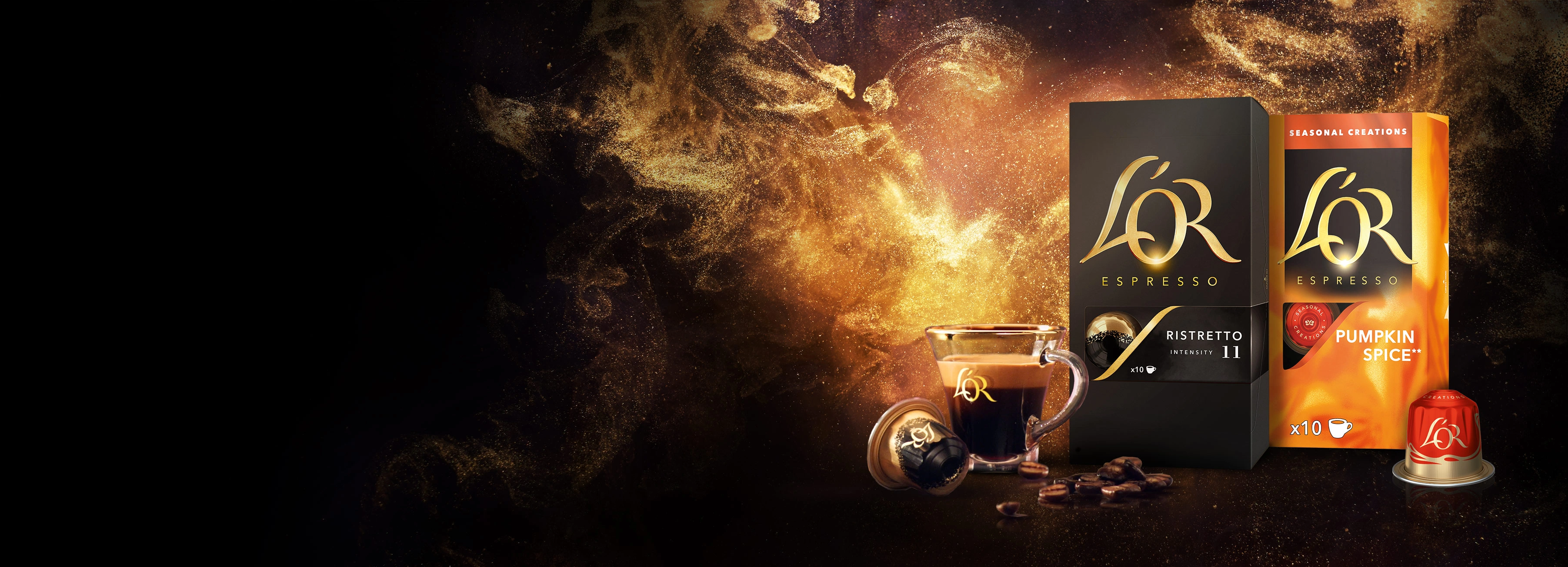 L'OR Ristretto en L'OR Pumpkin Spice verpakkingen met een espressokopje en capsules. Gouden glinsterende achtergrond.