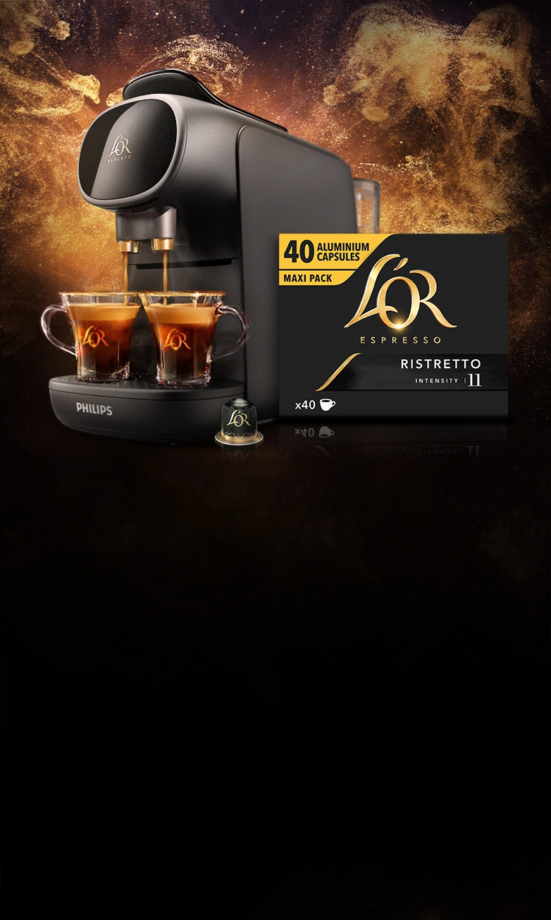 L'OR BARISTA Sublime cafetière avec des tasses et un pack de 40 Ristretto capsules. Fond doré scintillant. 