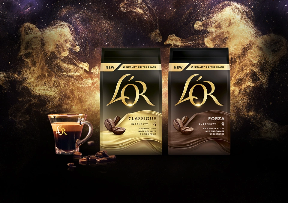 L'OR Classique beans and Forza beans packs with espresso cup. Golden glitter background.