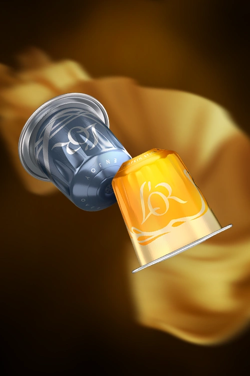 Deux capsules L'OR de la collection Specials, XXL Iced et Pumpkin Spice, en lévitation. Un tissu de soie dorée en arrière-plan.