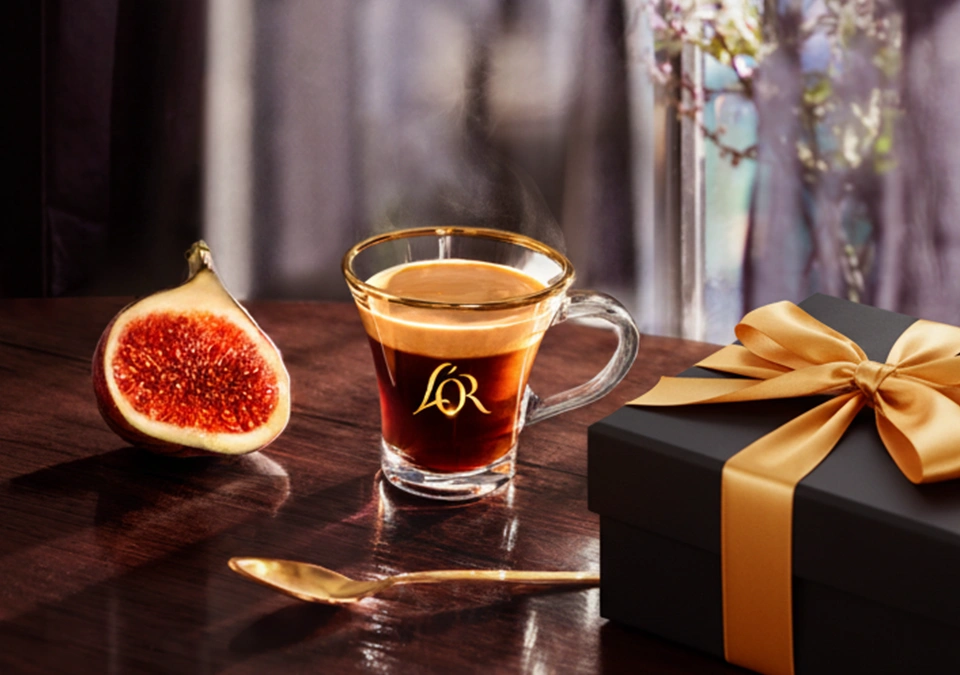 Espresso cup, black and gold gift box on a table.