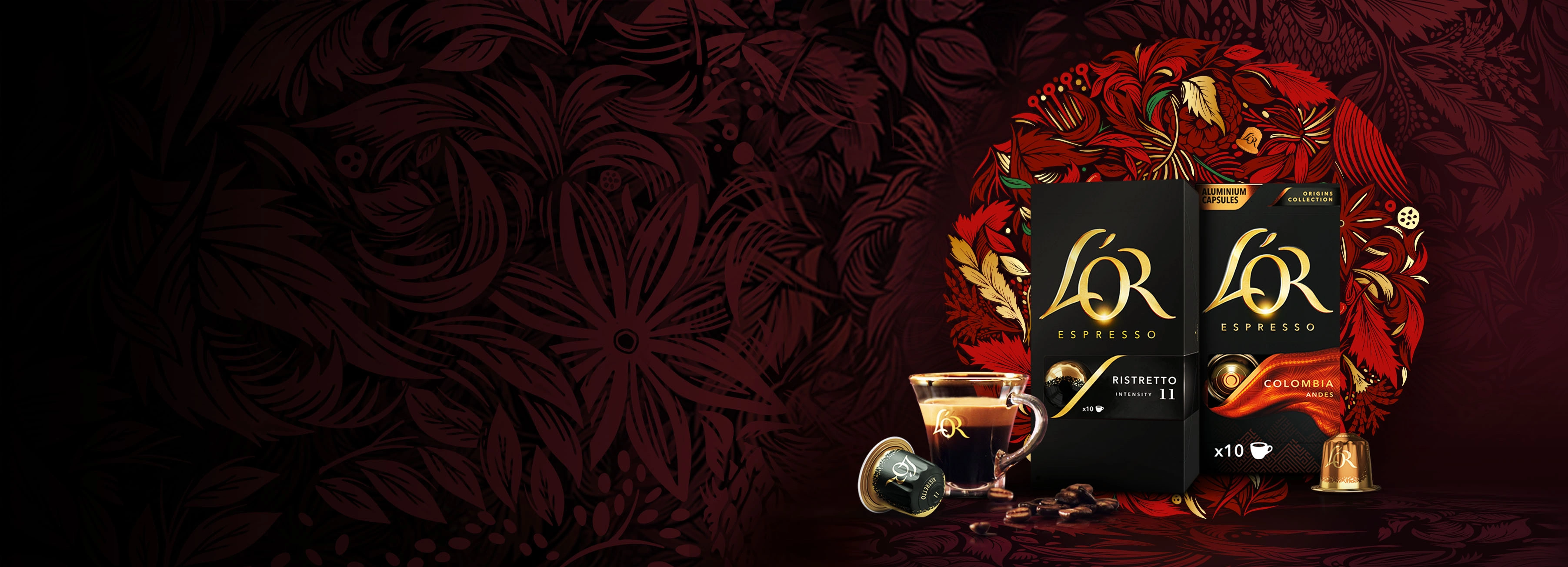L'OR Ristretto and Colombia packs with coffee cup, capsule and scattered beans on a red wreath background.
