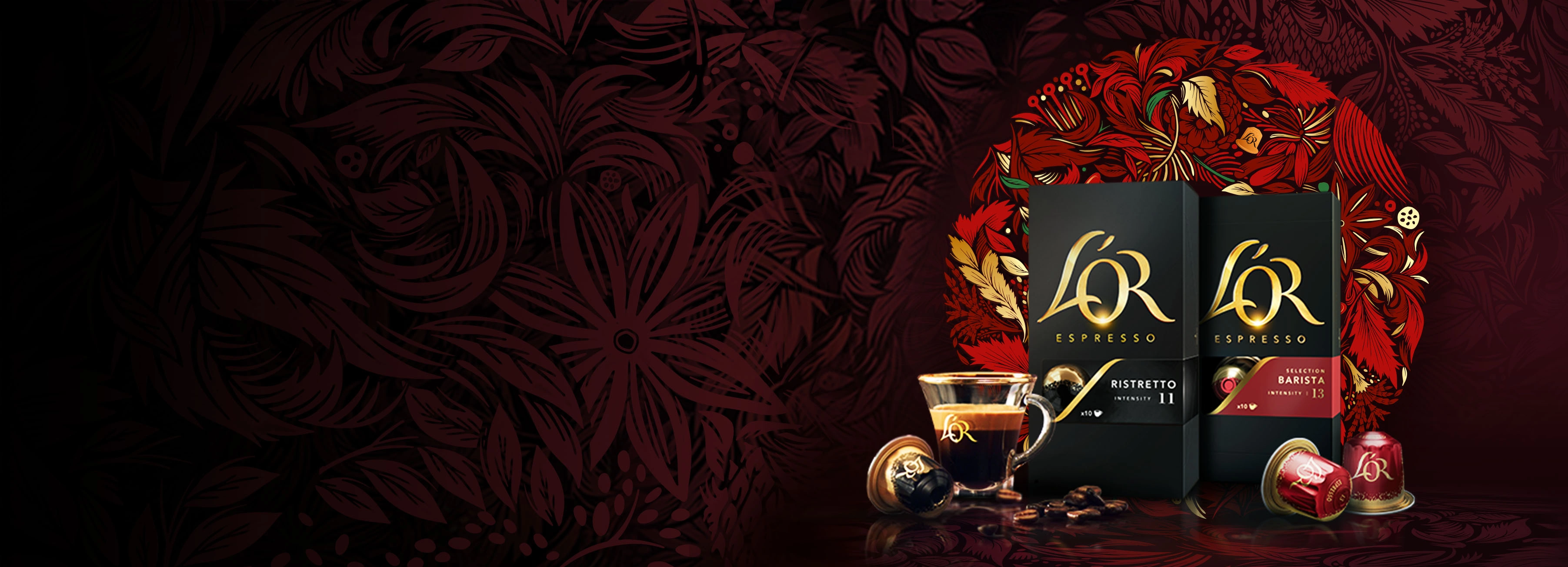 Confezioni L’OR Ristretto e Barista 13 con tazza di caffè, capsule e chicchi sparsi su uno sfondo di ghirlanda rossa.