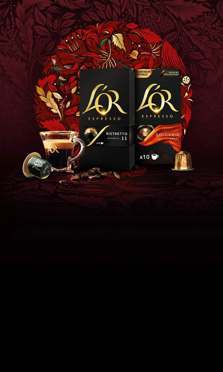 L'OR Ristretto and Colombia packs with coffee cup, capsule and scattered beans on a red wreath background.