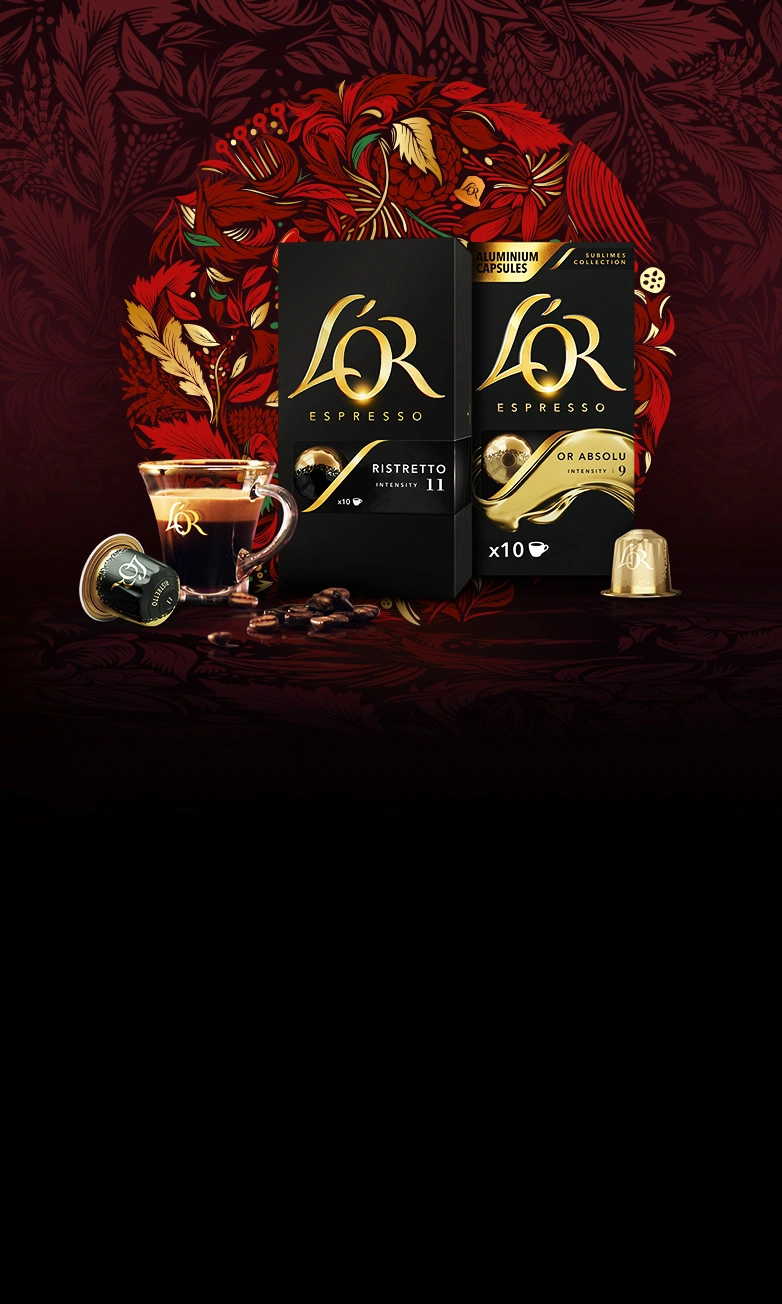 Paquets L’OR Ristretto et OR Absolu avec tasse de café, capsule et grains éparpillés sur un fond de couronne rouge.