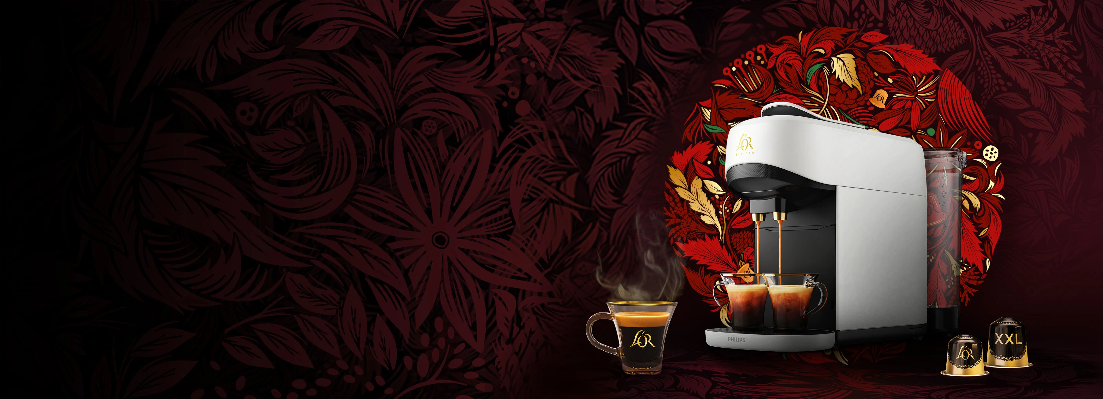 White L'OR Absolu coffee machine with coffee cups and Ristretto normal and XXL capsules on a red wreath background.