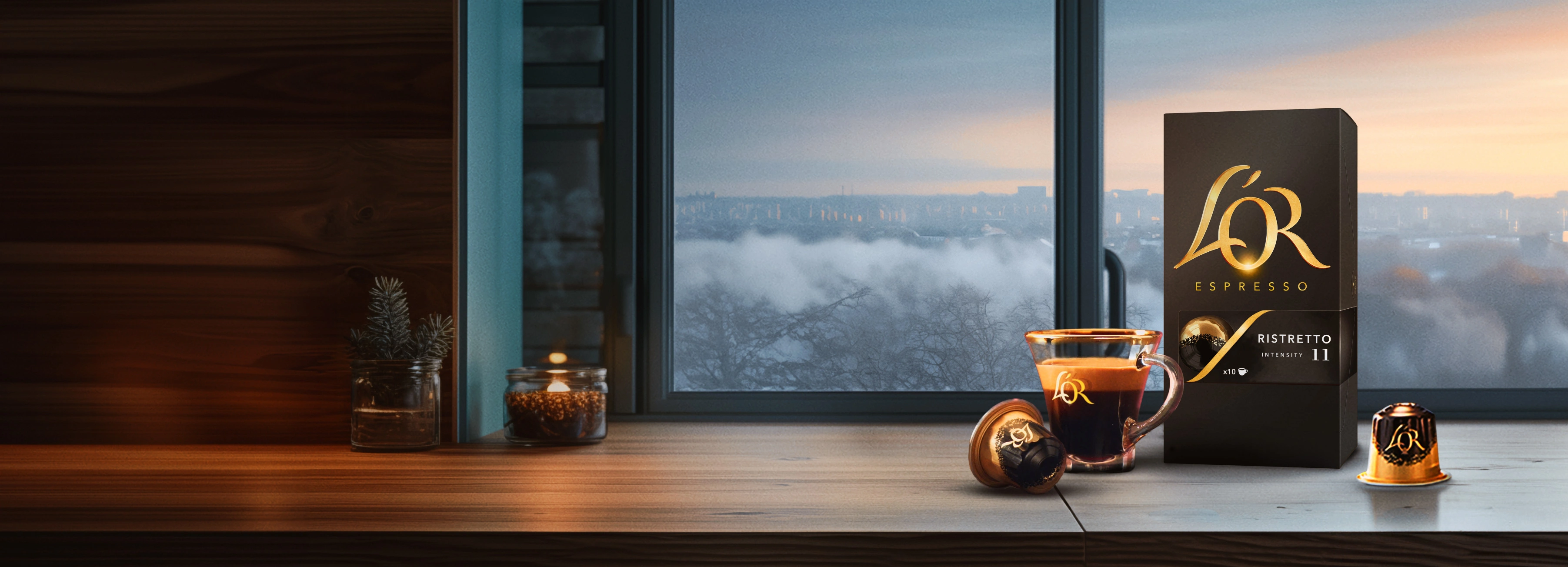 L'OR Ristretto pack with coffee cup and capsules and scattered beans on a wooden table with winter window background. 