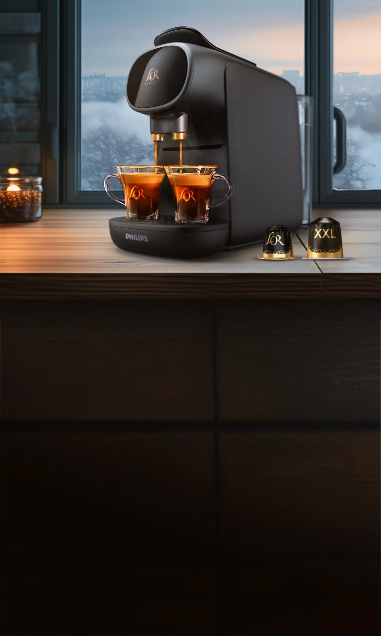 L'OR Sublime black coffee machine with Ristretto standard and XXL capsules on a wooden table with winter window background. 