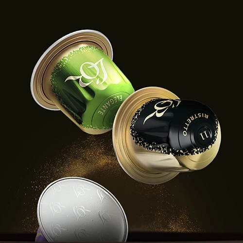 Premium L’OR koffiecapsules in goud‑ en groentinten die zwevend worden weergegeven met rondvliegend koffiepoeder, geschikt voor Nespresso‑machines