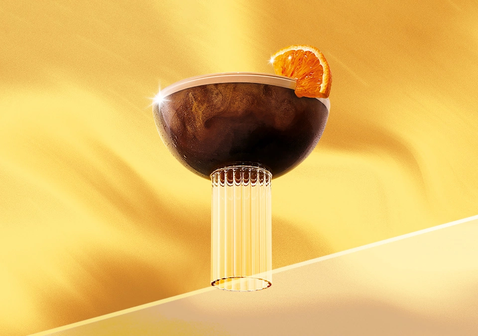 Verre de café chaud avec mousse et zeste d’orange sur fond doré