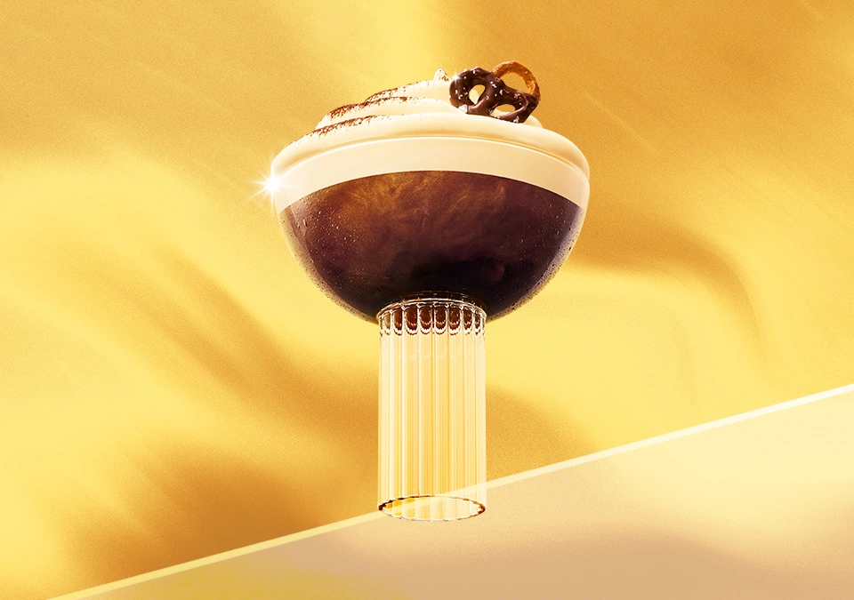 Espresso cremoso servido en copa elegante sobre fondo dorado