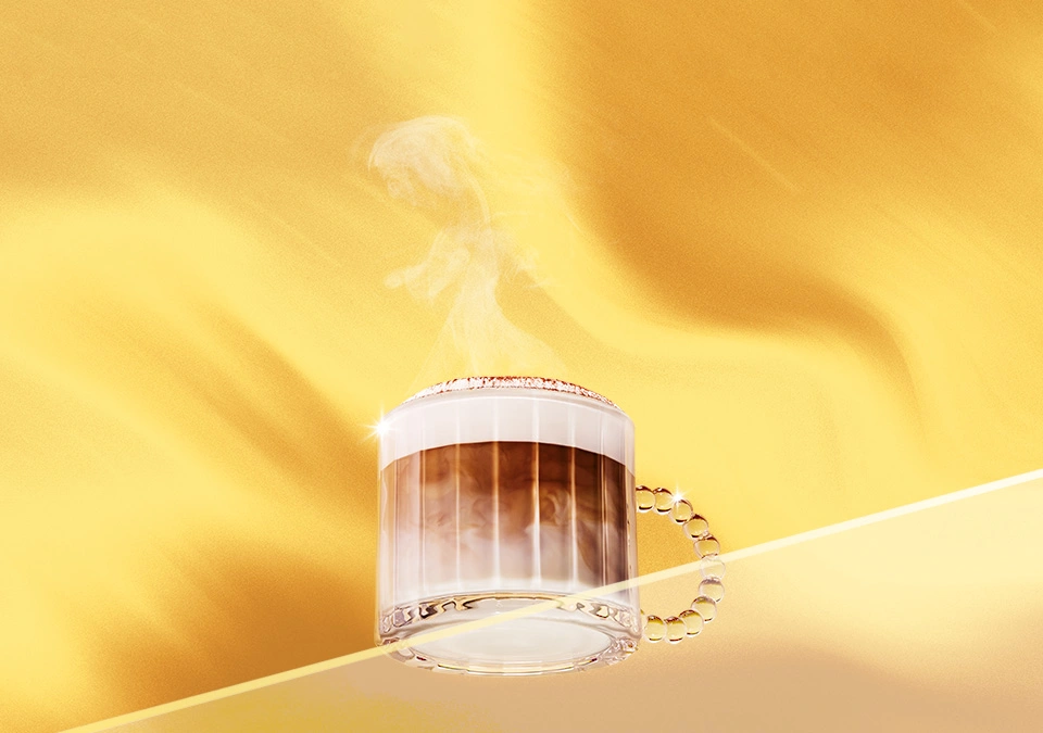 Café caliente con espuma en taza de vidrio sobre fondo dorado