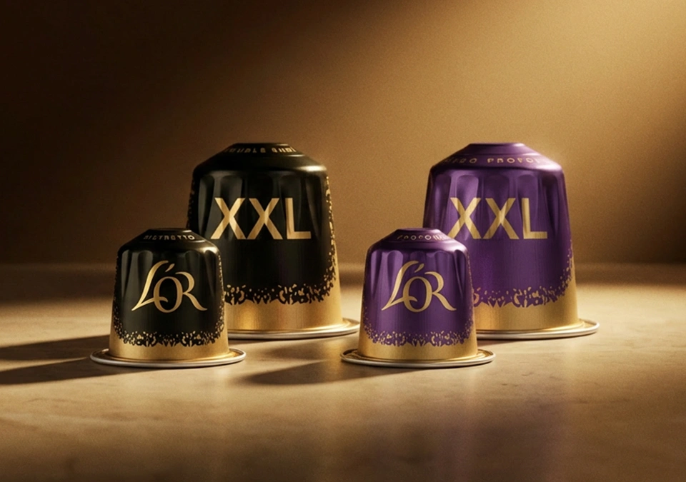 Packshots de cápsulas de café L'OR en formato XXL sobre una superficie iluminada con fondo oscuro