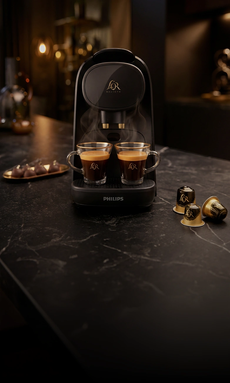 Máquina de café L'OR en una cocina con varias tazas de café preparadas y cápsulas alrededor