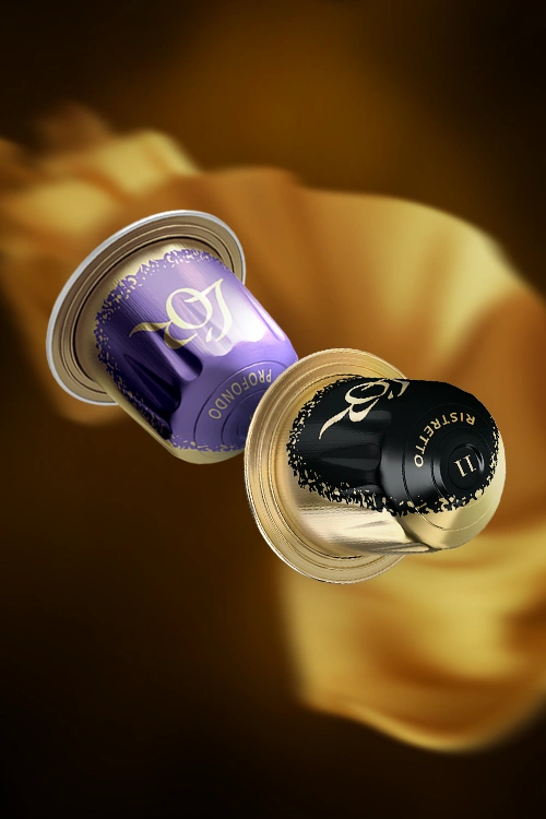 Deux capsules L'OR de la collection Flavors, Ristretto et Profondo, en lévitation. Un tissu de soie dorée en arrière-plan.