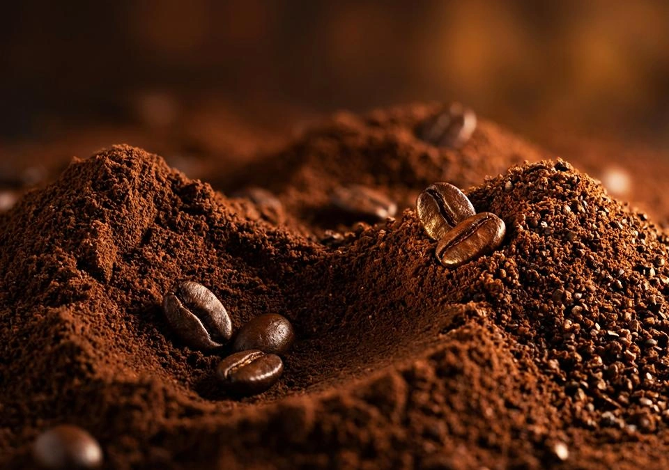 Montón de café molido con granos enteros visibles en la superficie