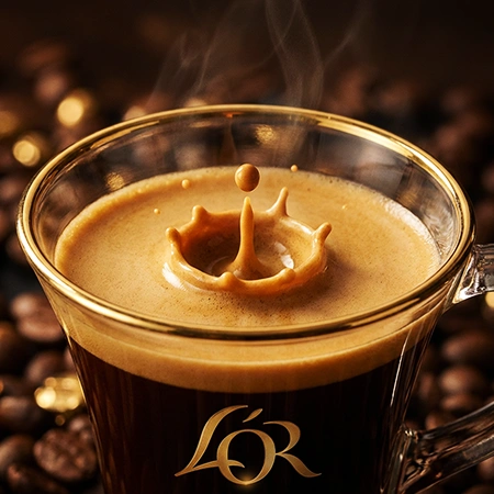Taza de café L'OR vista desde arriba con crema líquida vertiéndose en el centro