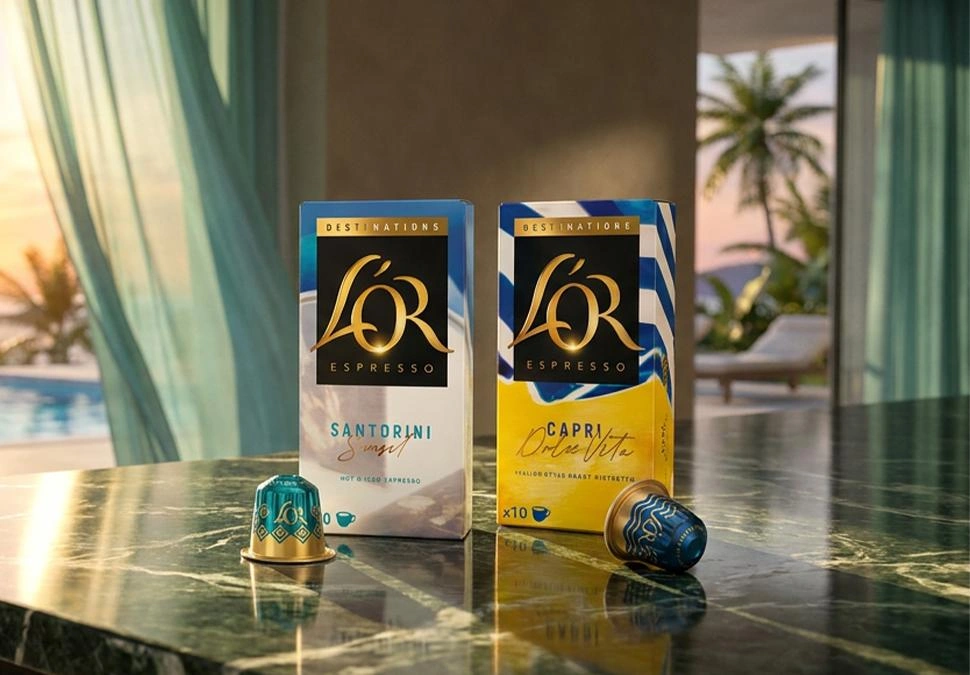 L’OR Espresso Santorini and Capri capsule packs displayed on a table with a sunlit terrace and pool view in the background