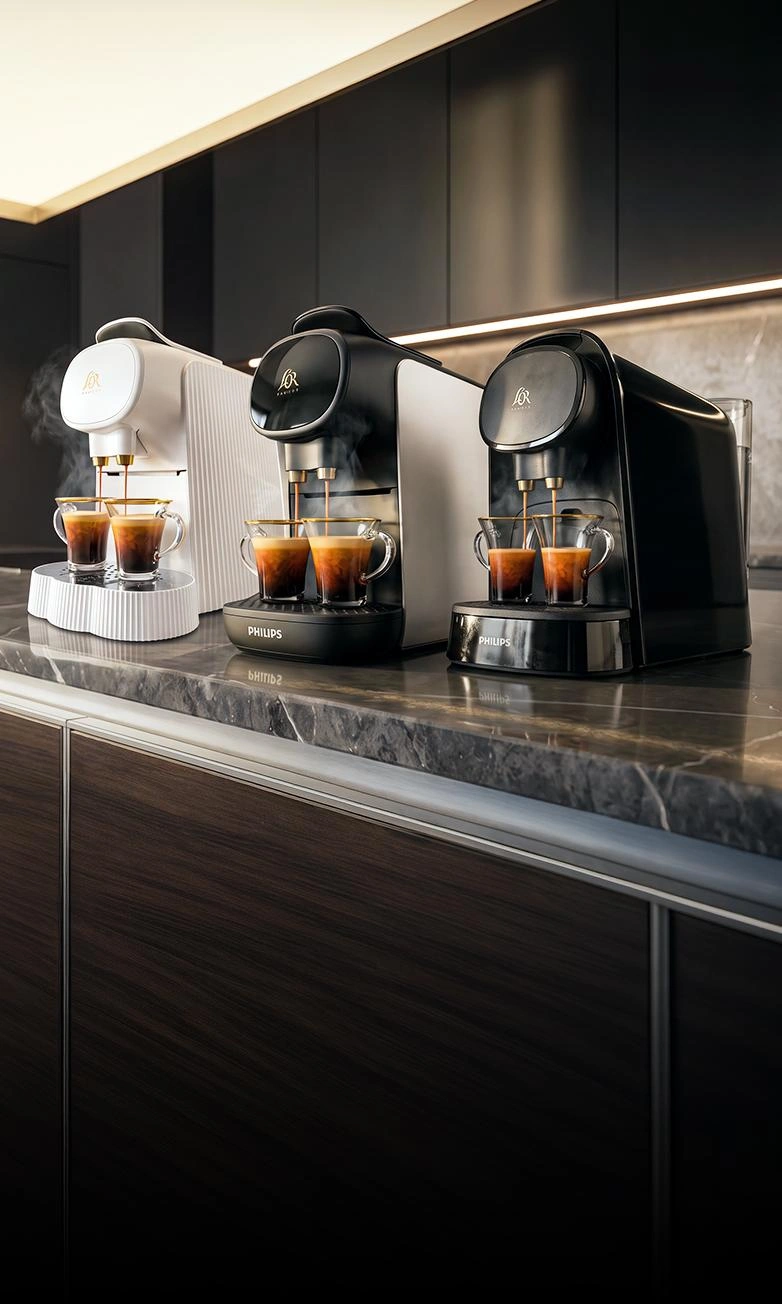 Two L’OR BARISTA coffee machines brewing espressos side by side on a dark gradient background.