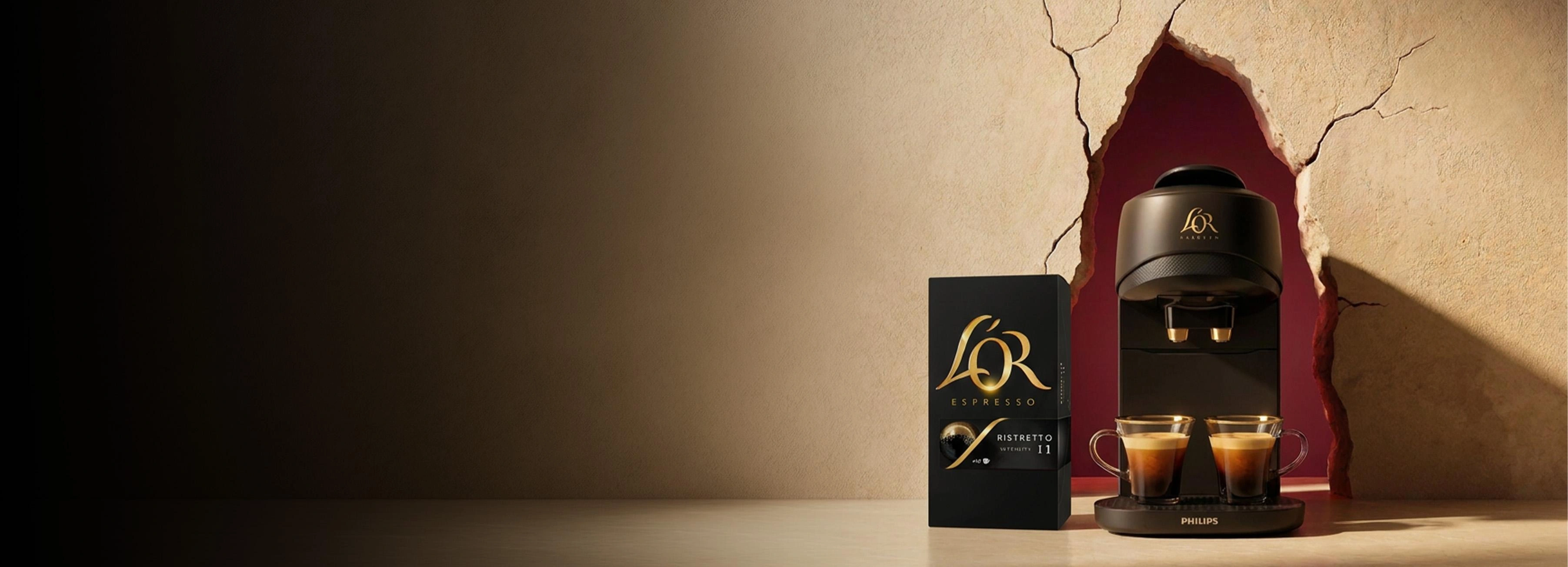 L'OR cadeaudoos met koffiecapsules, tegen een donkere, feestelijke achtergrond.