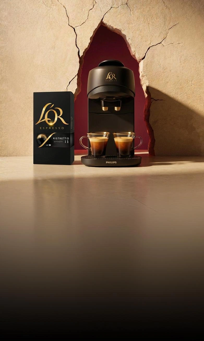 Caja de regalo de cápsulas de café L'OR sobre un fondo oscuro y festivo.