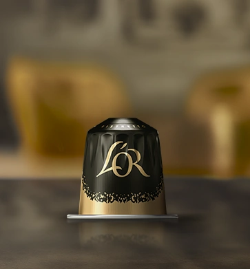 Black L'OR coffee capsule on a dark saucer.