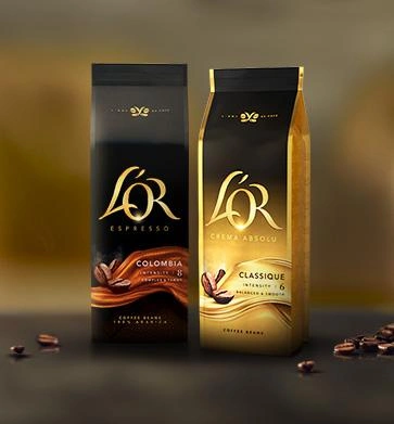 Two L’OR coffee bean bags displayed with scattered roasted coffee beans.